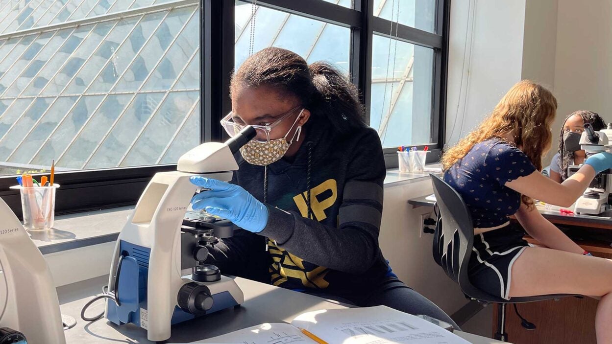 Photo of a DNALC Student with microscope