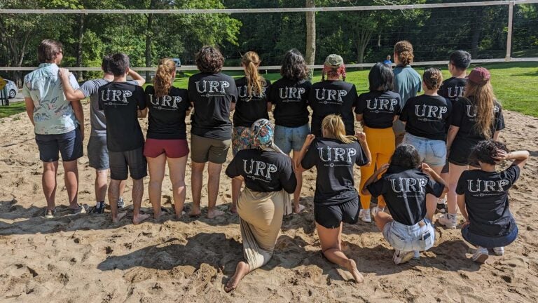 photo of the 2023 Undergraduate Research Program students post volleyball game showing the back of their t-shirts